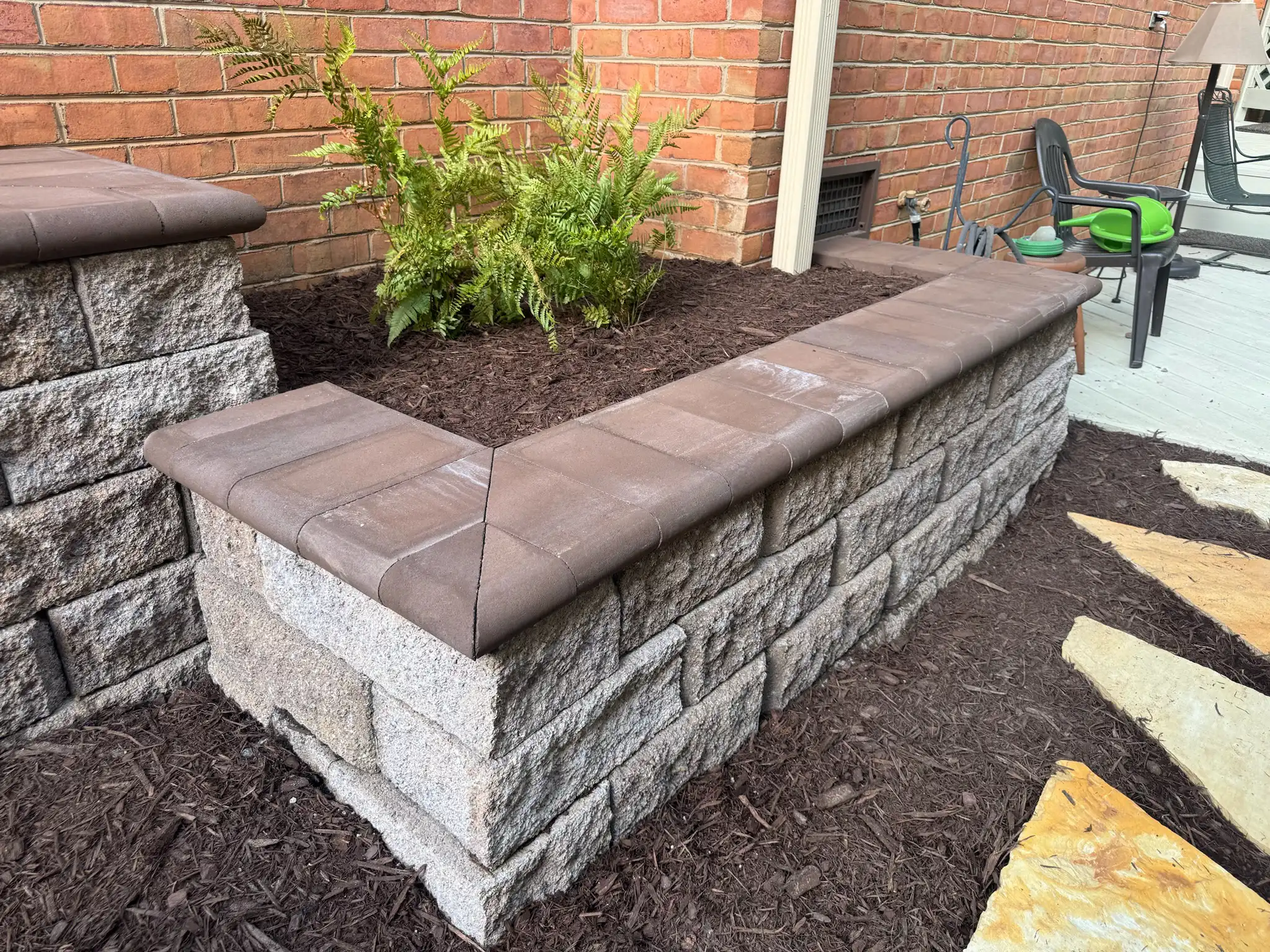 Retaining wall with coping and landscape bed