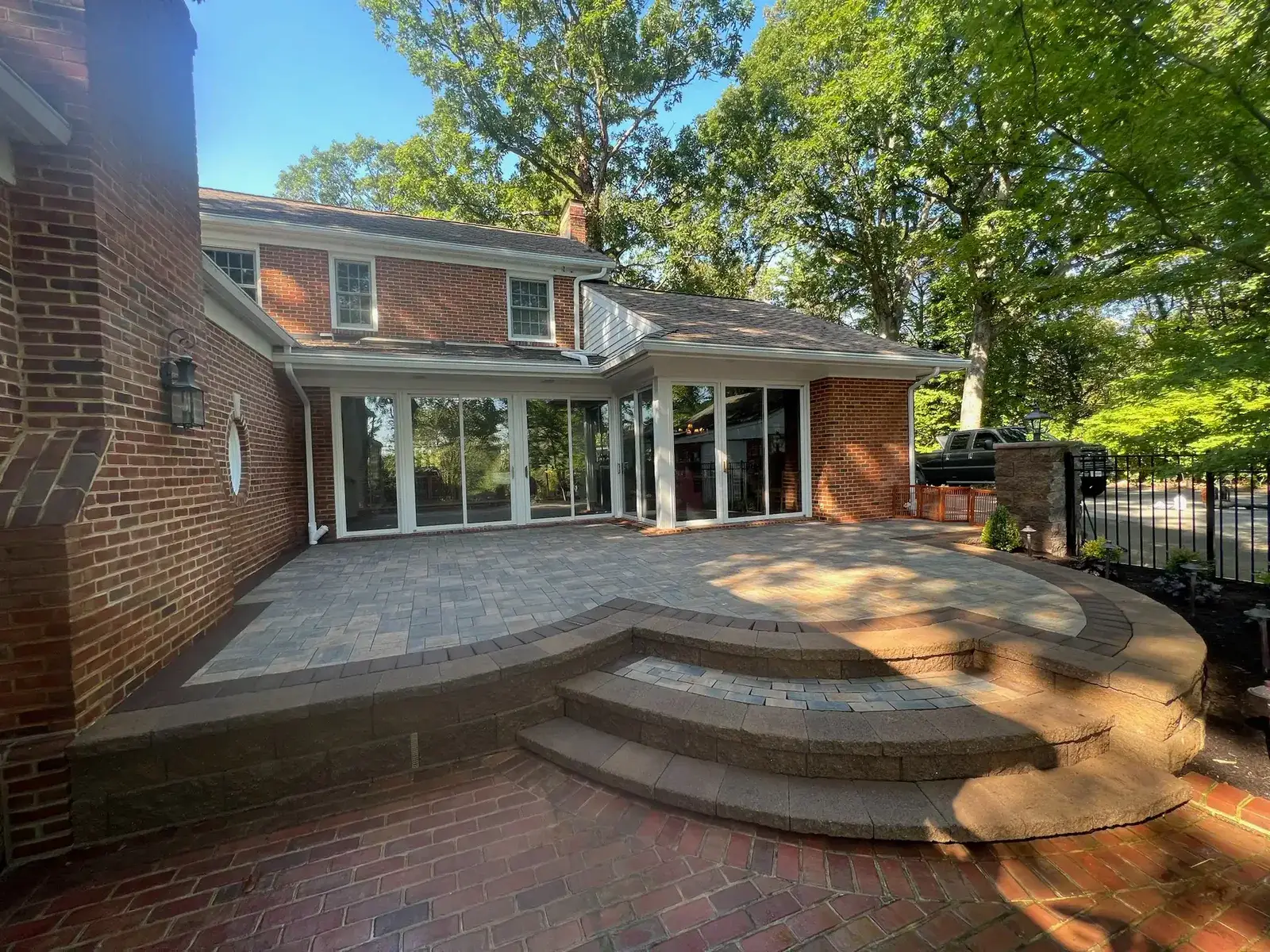 Multi-level two-tier paver patio with curved steps and sitting walls — Ridgestone Excavating